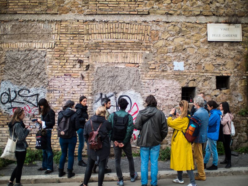 A crowd of people in front of a wall 